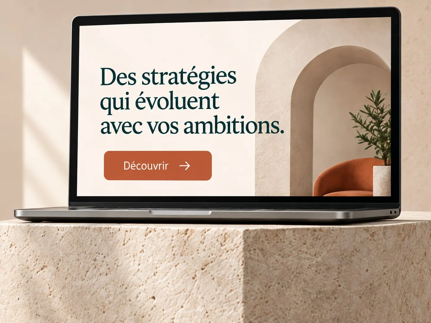Ordinateur portable posé sur un socle en pierre claire, affichant une maquette de site web.