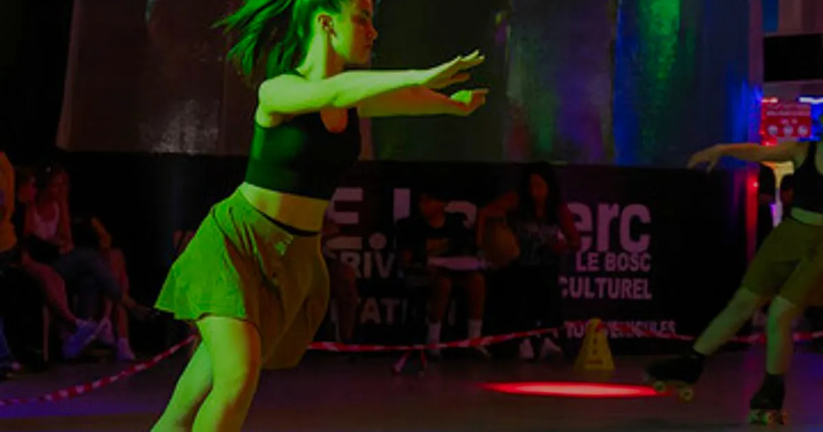Patineuse sur une piste de roller éclairée en vert, rouge et bleu
